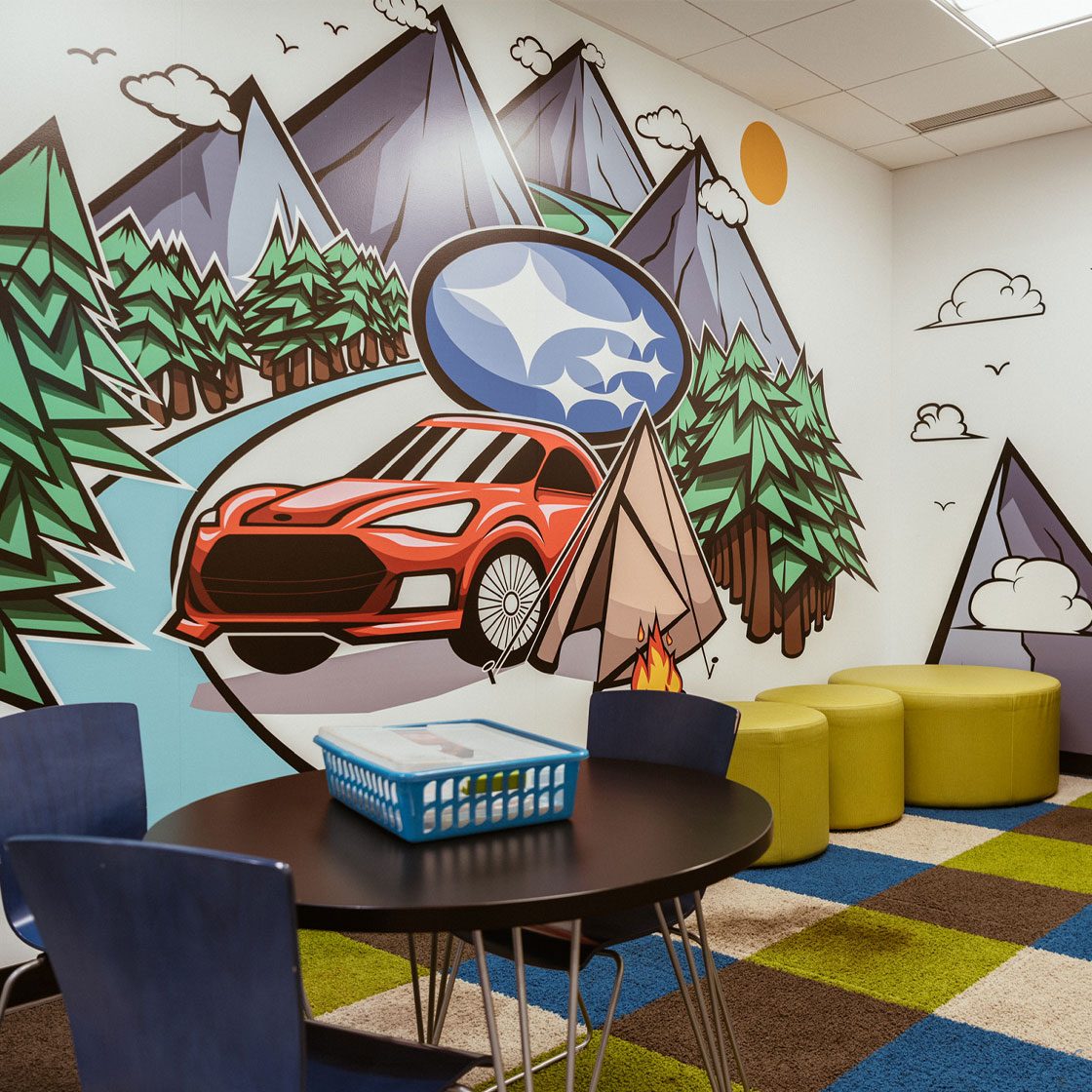 A kids playroom with a graphically illustrated vinyl mural