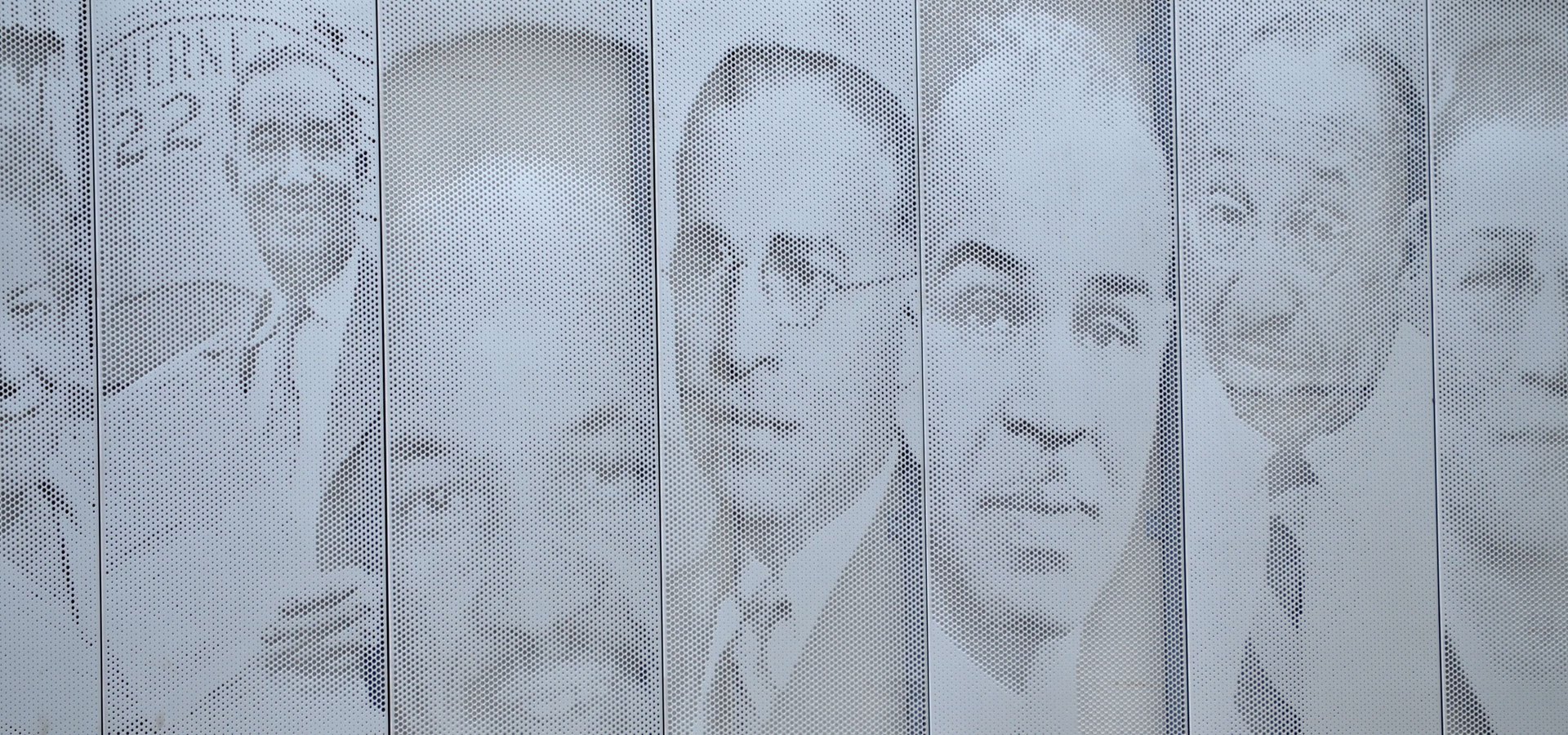 A building wall with decorative portraits etched in metal