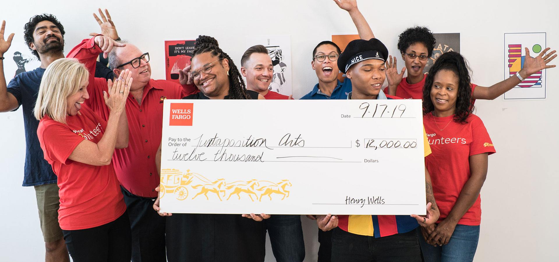 Several people looking celebratory and holding a giant check for $12,000 from Wells Fargo