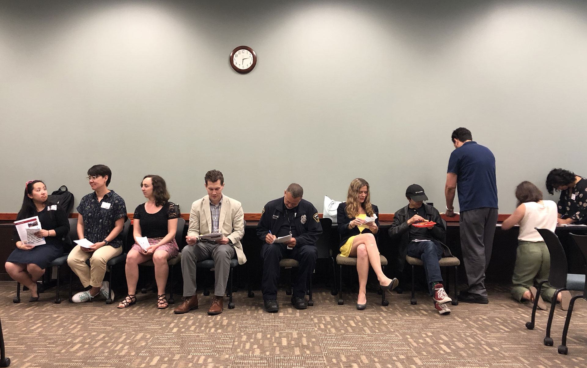 A group of people sitting in a row next to each other.