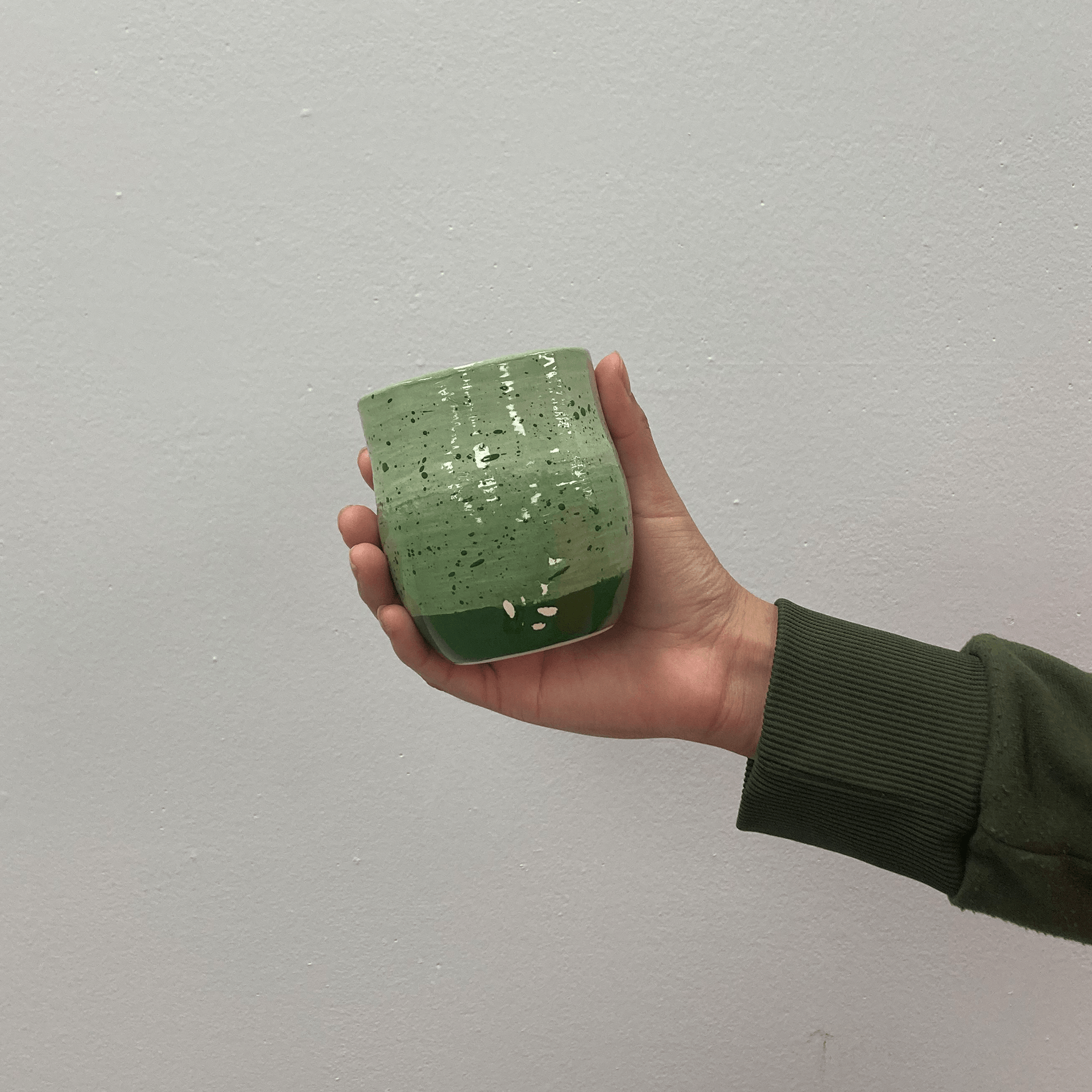 Green ceramic mug in front of white background