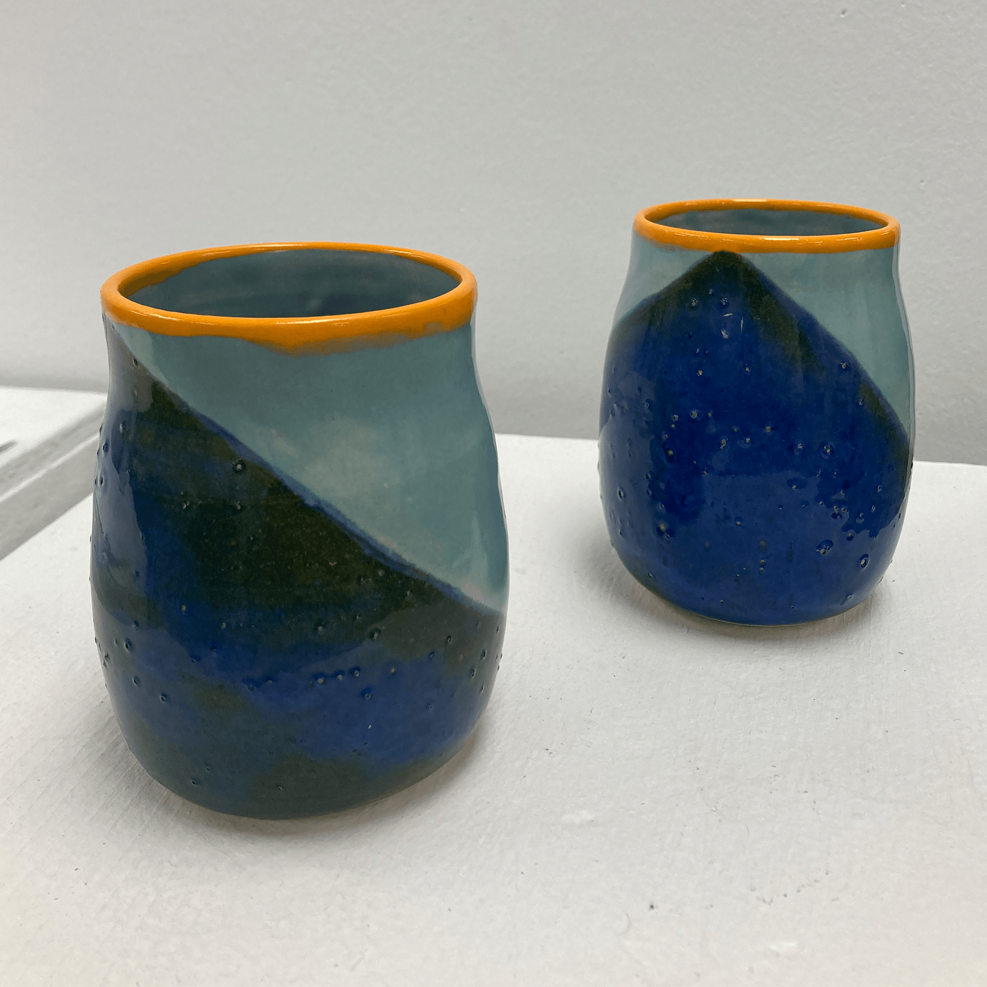 Set of blue and yellow mugs on display stand