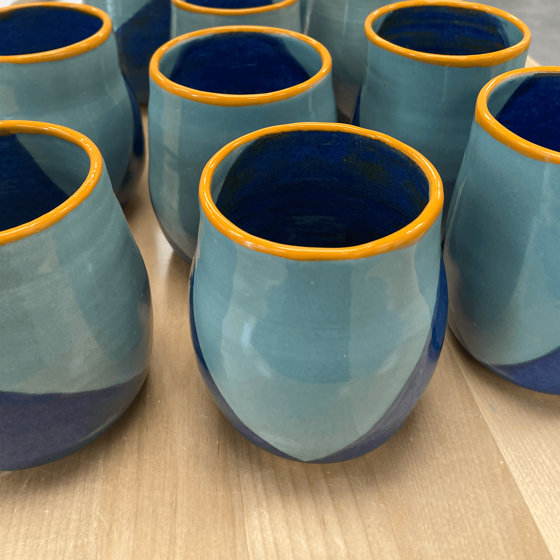 Set of blue and yellow mugs on a table